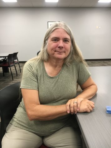 Award-winning author and CF alum Sandra Friend sitting at a table in the newly renovated CF Ocala campus library.