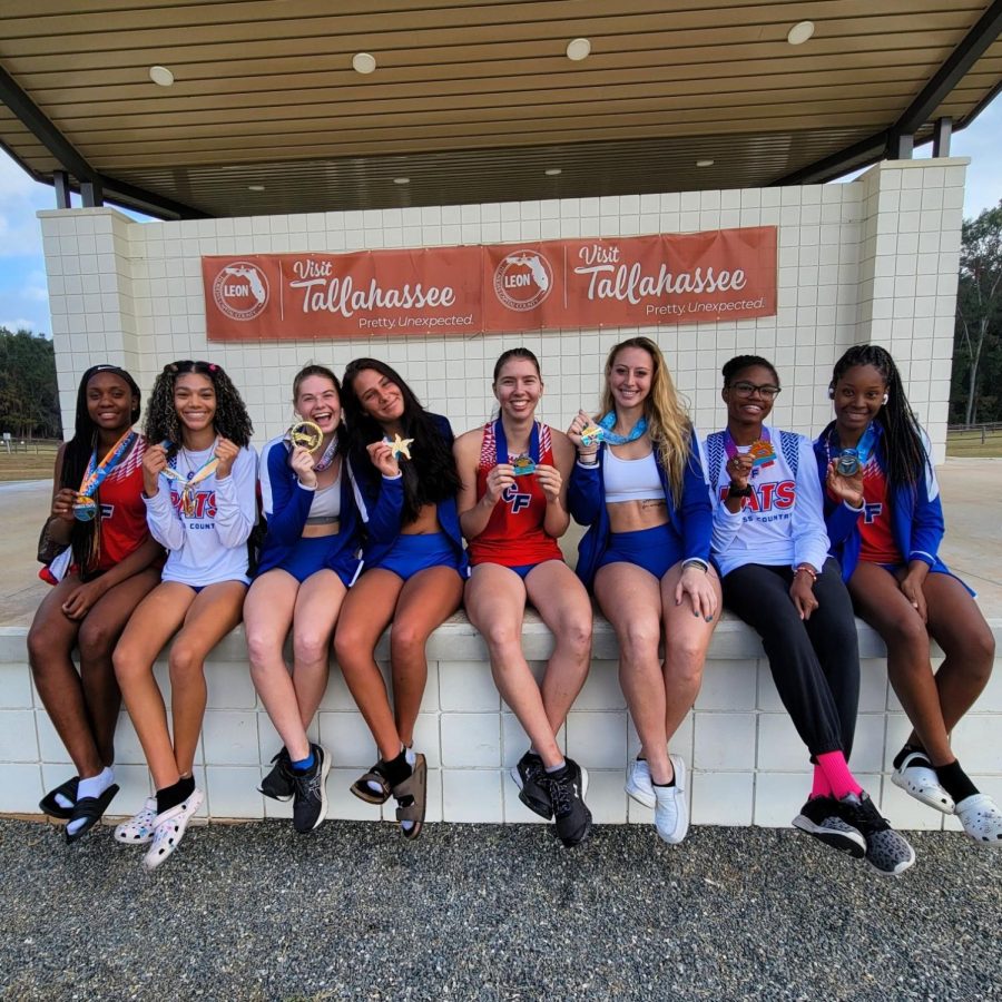 The CF cross country team posing with their medals from the qualifying race at Regionals.