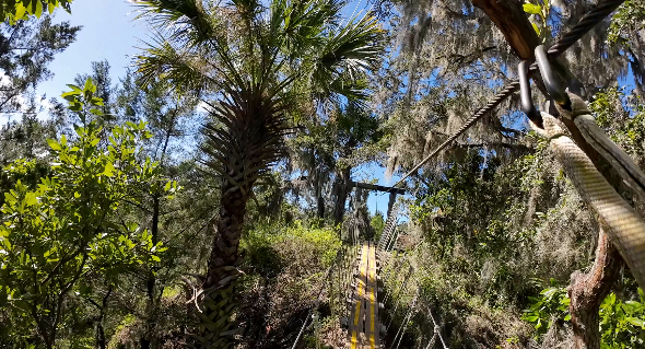 James Huston crossing a suspended bridge at The Canyons Zip Line and Adventure Park.