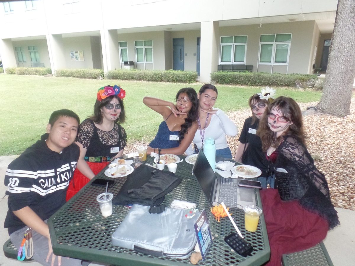 Students posing for a photo at the Día de Los Muertos event.